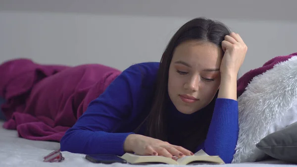 Νεαρή Γυναίκα Ξαπλώνει Στο Κρεβάτι Διαβάζοντας Ένα Βιβλίο — Φωτογραφία Αρχείου