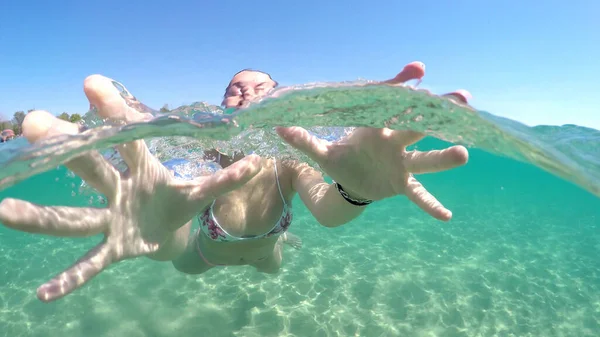 幸せな笑顔ティーン女の子持っています楽しいです水泳水中と与えますキスにカメラ Goproドームショット — ストック写真