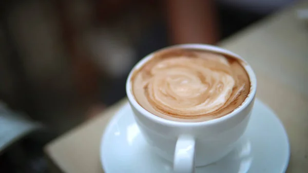 Woman mixing her coffee with a spoon in a coffee shop