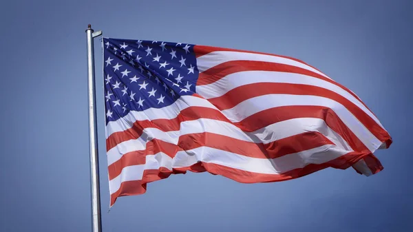 Zbliżenie Dużej Amerykańskiej Flagi Machającej Przed Błękitnym Niebem Białą Chmurą — Zdjęcie stockowe