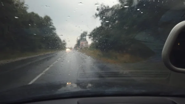 山のアスファルトの道路を運転雨滴と車のフロントガラスを介して運転Pov — ストック写真