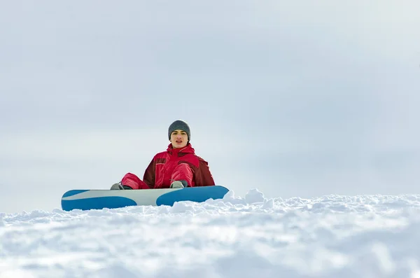 Сноубордист Красном Скисуите Сидит Снегу Вершине Горной Вершины — стоковое фото