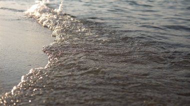 Kumsalda kumları silip süpüren kamera dalgalarıyla