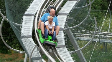 Bansko, Bulgaristan - 20 Ağustos 2019: Erkek ve kız yaz eğlence treni yolculuğunun tadını çıkarıyorlar. Kırmızı bir lunaparkta heyecanlı bir yolculuktan zevk alırken komik bir ifadeleri vardır.