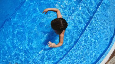 Yüzme havuzuna atlayan heyecanlı küçük kız. Mutlu yaz tatilleri.