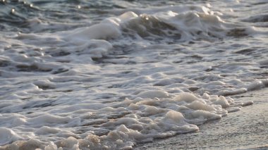 Dalgaların yakın çekim sahili ıslak kumlar kuruyor, sinematik dof
