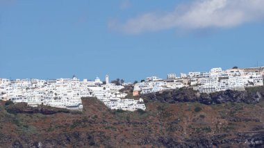 Denizden Santorini kalderasına panoramik manzara ve Fira kasabasının ikonik mimarisi