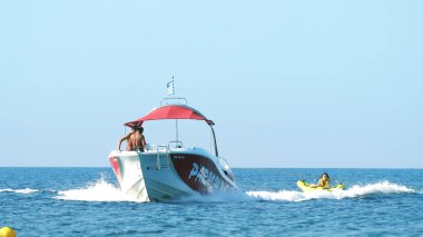 Halkidiki, Yunanistan - 25 Haziran 2018: Tropikal turkuaz körfezde aşırı süratli sürat teknesi su sporları küfürü