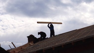 Makedonya 'nın Kocani kenti - 10 Ekim 2018: Siluet Müteahhit Arkaplanda Mavi Gökyüzü ile Çatı Üzerinde Çalışıyor