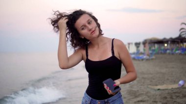 Gün batımında güneşli sahilde dans eden tatlı kız.