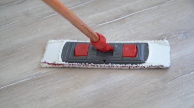 Yerdeki paspasın üzerine yakın plan temizleme uzmanı tarafından tutuluyor.