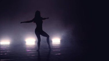 Genç, güzel, çağdaş balerin dumanlı sahnede modern bale yapıyor.