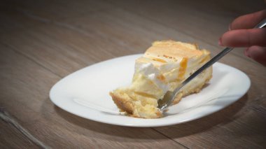 Lezzetli bir parça şeftalili peynirli kek yiyorum.