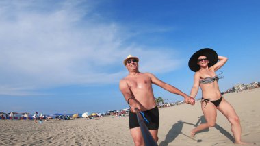 Kumsalda orta yaşlı bir çift etrafında dönerek eğleniyor.