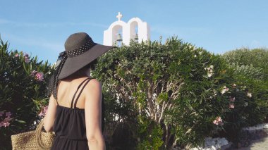 Yunanistan 'ın Santorini kentinde dar bir sokakta yürüyen zarif bir kadının ardından