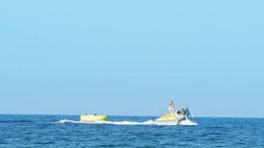 Halkidiki, Yunanistan - 25 Haziran 2018: Tropikal turkuaz körfezde aşırı süratli sürat teknesi su sporları küfürü