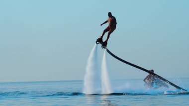 Santorini, Yunanistan - 26 Ağustos, 2019: Tropikal deniz ve su sporları alanında profesyonel profesyonel bir uçuş sörfçüsü. Yaz tatili açık hava sporu