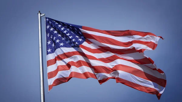 Zbliżenie Dużej Amerykańskiej Flagi Machającej Przed Błękitnym Niebem Białą Chmurą — Zdjęcie stockowe