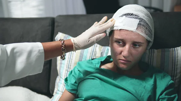 头颅手术后 穿着制服的医生检查女病人 病人躺在病床上 — 图库照片