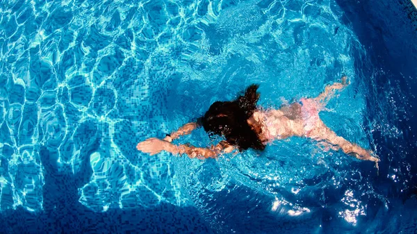 豪華なリゾートでプールでの小さな女の子のダイビングの空中ビュー — ストック写真