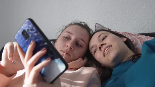 Due Sorelle Sorridenti Felici Sono Sdraiate Sul Letto Usando Smartphone — Foto Stock