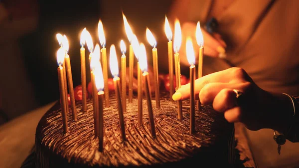 Frau Zündet Kerzen Auf Geburtstagstorte — Stockfoto