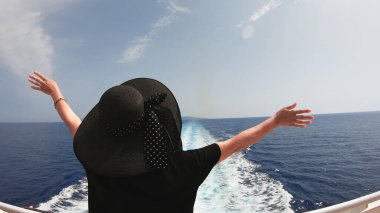 Güvertedeki feribottan el sallayan kadın.