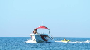 Halkidiki, Yunanistan - 25 Haziran 2018: Tropikal turkuaz körfezde aşırı süratli sürat teknesi su sporları küfürü