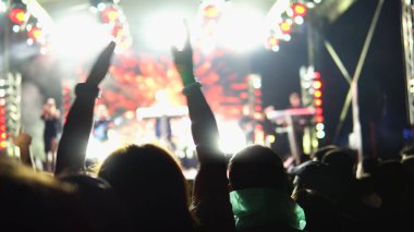 Açık hava konserinde hayranlar tezahürat yapıyor.