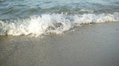 Kumsalda kumları silip süpüren kamera dalgalarıyla