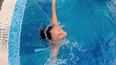Havuzda hidroterapiden hoşlanan bir kadın