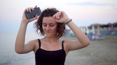 Gün batımında güneşli sahilde dans eden tatlı kız.