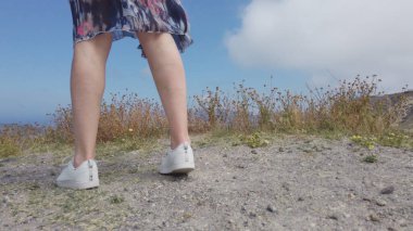 Kadın turist volkanik ada manzarasının keyfini çıkarıyor, sabahın erken saatlerinde Santorini, Akdeniz, Yunanistan 'da iki elini kaldırıyor, yavaş çekim