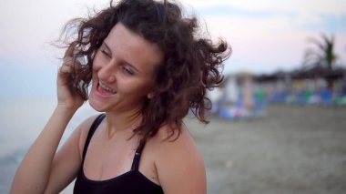 Gün batımında güneşli sahilde dans eden tatlı kız.