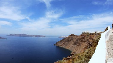 Fira, Santorini 'nin çatıları üzerinde panoramik çekim. Kameni volkanı adasına demir atmış feribot botları, el kamerasıyla çekilmiş.