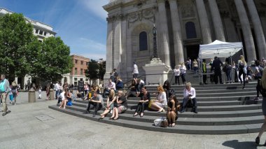 LONDON, ENGLAND- 29 Haziran 2017: Sıcak güneşli bir günde St. Paul Katedrali 'nin önündeki merdivenlerde oturan turist kalabalığı.