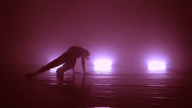 Genç, havalı bir kadın, kulüpte ışıklarla erotik danslar yapıyor.