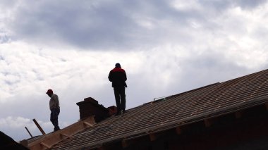 Makedonya 'nın Kocani kenti - 10 Ekim 2018: Siluet Müteahhit Arkaplanda Mavi Gökyüzü ile Çatı Üzerinde Çalışıyor