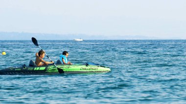 Halkidiki, Yunanistan - 25 Haziran 2018: Aile denizde kürek çeken bir teknede eğleniyor