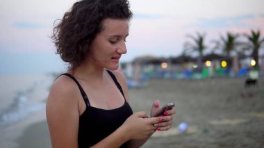 Gün batımında güneşli sahilde dans eden tatlı kız.