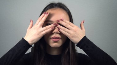 Utangaç, baştan çıkarıcı kız kameraya bakıp gülümsüyor.