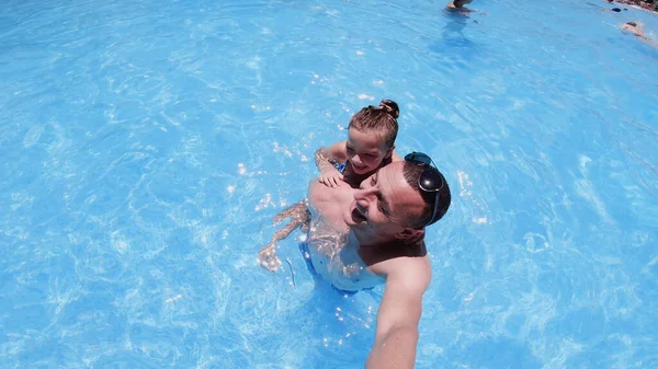 爸爸和女儿在游泳池里玩 女孩骑在男人身上 — 图库照片