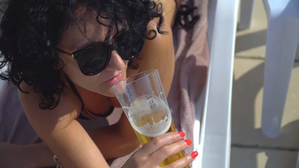 Γυναίκα Πίνοντας Μπύρα Ένα Ποτήρι Στην Παραλία Ξαπλωμένη Στην Ξαπλώστρα — Φωτογραφία Αρχείου