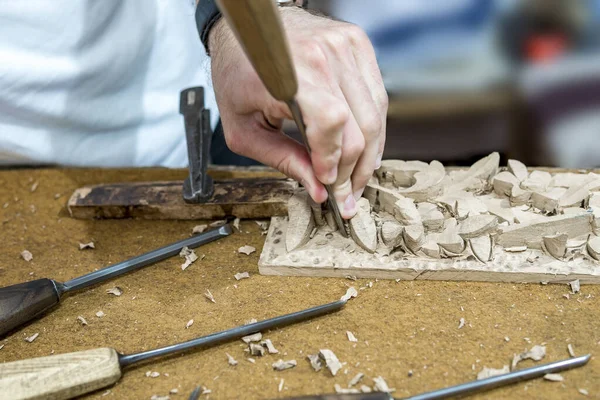 hands of the craftsman carve a bas-relief