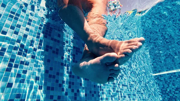 リラックスする前にプールで彼の足をスイング男性の遅い動き — ストック写真