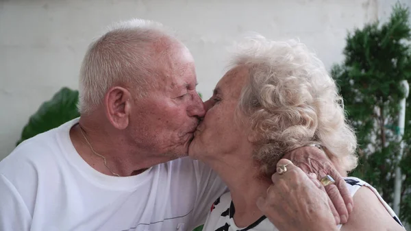 Starsza Para Całująca Się Domu Siedząca Ganku Emerytura Koncepcja Miłości — Zdjęcie stockowe