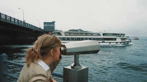 金发女人用双目望远镜观察船只 海景和伊斯坦布尔的亚洲一侧 望向远方游客观景台 — 图库照片