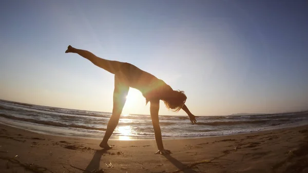 日没時に海岸で健康な女性体操を行う — ストック写真