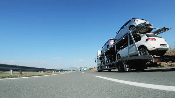 大型トラック 車の輸送業者は 高速道路を走行する中古車を提供します — ストック写真