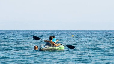 Halkidiki, Yunanistan - 25 Haziran 2018: Aile denizde kürek çeken bir teknede eğleniyor